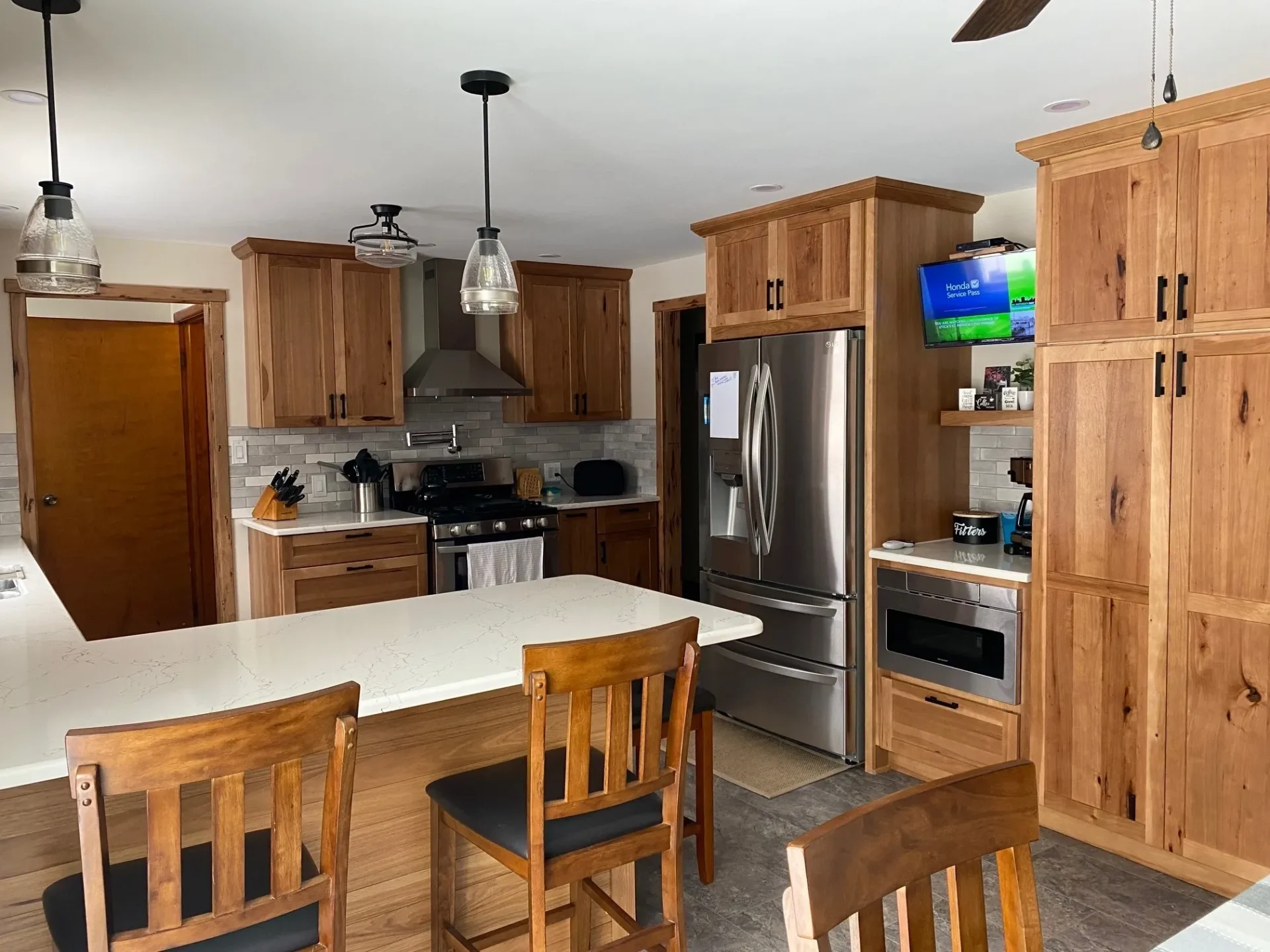 A kitchen with wood cabinets and counter tops.